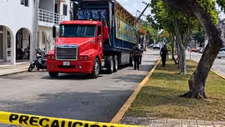 Tráiler con juegos mecánicos queda atorado en cables y provoca inclinación de poste en Cozumel