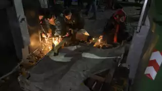 Mujeres encienden velas durante una vigilia frente a la casa donde dos mujeres lesbianas fueron asesinadas