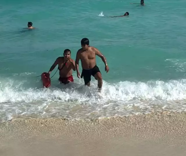 El bombero en labores de guardavida se percató de la situación y se apresuró hacia el joven