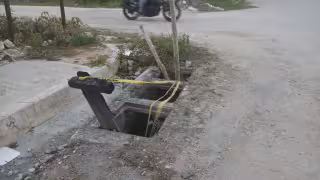 Colonos colocan cinta y madera para señalar riesgo en alcantarilla de Campeche