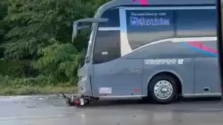 La motocicleta quedó debajo de la pesada unidad tras el impacto.