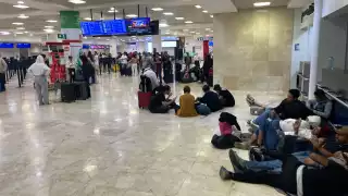 Hay decenas de pasajeros esperando en el aeropuerto de Cancún