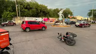 Moto de plataforma de reparto impacta contra auto en la glorieta de los Delfines; sin lesionados