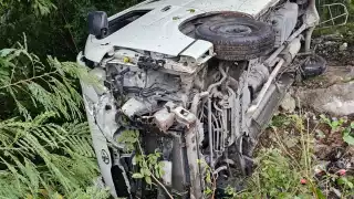 La camioneta tipo van terminó volcada entre la maleza.