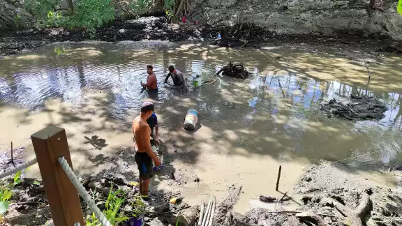Con ayuda de cubetas y palas, comenzaron a extraer el lodo del agua