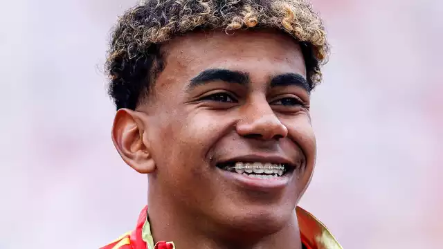 Lamine Yamal sostiene el trofeo al mejor jugador joven de la Eurocopa 2024, rodeado de sus compañeros de la selección española tras la victoria en la final.