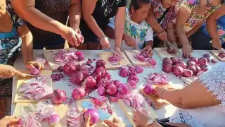 Integrantes de un gremio participan en el Dzan Cebolla, previo al inicio de las fiestas del pueblo
