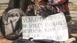 La pequeña sostiene un cartel con la esperanza de vender los utensilios