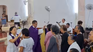 Fieles reciben la ceniza durante la misa de Miércoles de Ceniza en la Iglesia de la Santa Cruz, marcando el inicio de la Cuaresma en la Zona Maya