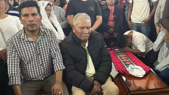 El padre del sacerdote Marcelo Pérez junto al ataud donde se encuentran el cuerpo de su hijo, asesinado el domingo pasado en Chiapas