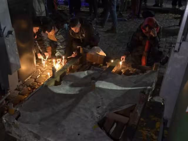 Mujeres encienden velas durante una vigilia frente a la casa donde dos mujeres lesbianas fueron asesinadas