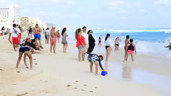 Mientras unos admiraban el mar turquesa, otros visitantes hacían fila para retratarse en el parador fotográfico de Cancún