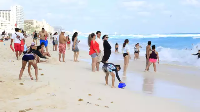 Mientras unos admiraban el mar turquesa, otros visitantes hacían fila para retratarse en el parador fotográfico de Cancún