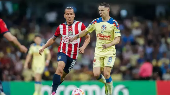 Fernando "Oso" González y Álvaro Fidalgo disputan el esférico en el Clásico Nacional
