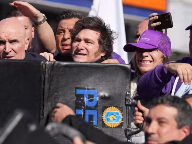 Ante la agresión, efectivos policiales usaron escudos para proteger al presidente, quien fue trasladado a un vehículo blindado