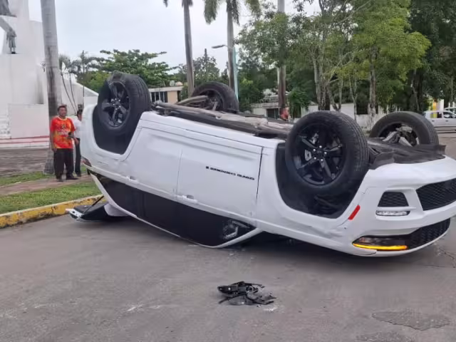 Transporte colectivo no respeta el semáforo y provoca que un automóvil termine boca abajo con dos personas policontundidas