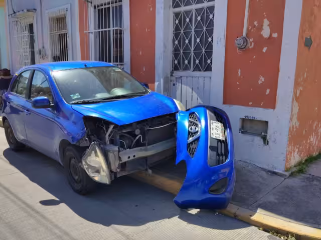 El Nissan March sufrió severos daños en el frente y quedó sobre la banqueta.