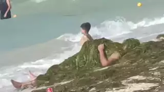 Bañista se cubre de sargazo en las playas del puerto de Progreso para librar el intenso sol  