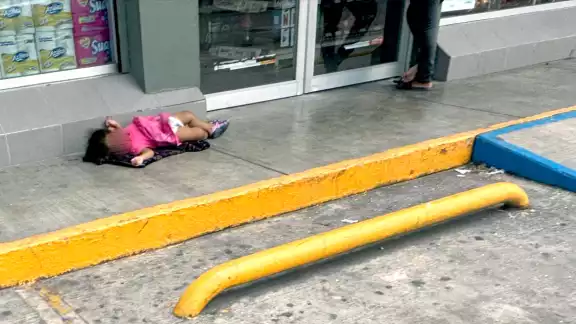La madre abría las puertas del Oxxo a cambio de monedas, mientras la niña dormía en el suelo, bajo el intenso calor La madre abría las puertas del Oxxo a cambio de monedas, mientras la niña dormía en el suelo, bajo el intenso calor