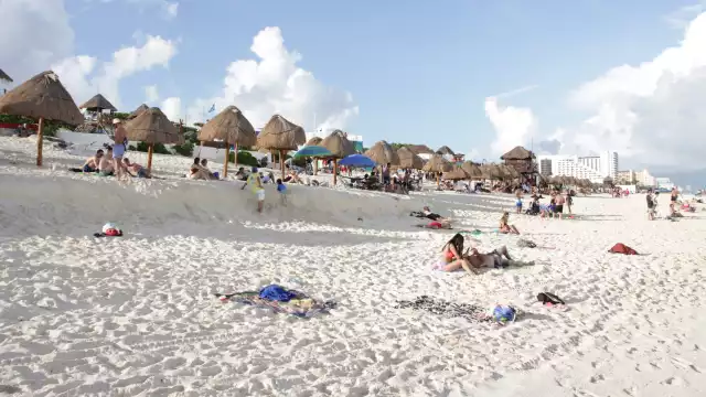 Pese al clima y las temperaturas, turistas van a las playas de la ZH de Cancún