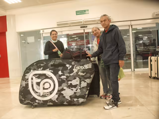 Con su enorme maleta, en donde lleva su pesada bicicleta, la colombiana Erika visitó Quintana Roo en compañía de sus padres