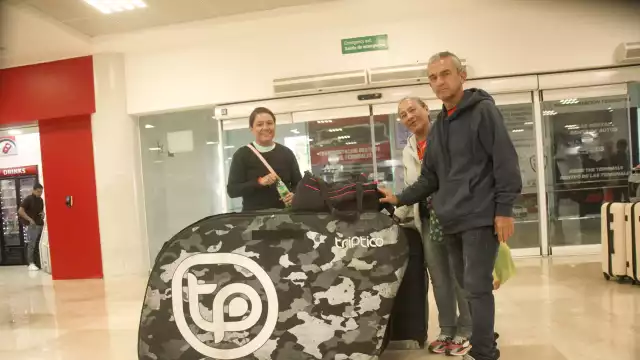 Con su enorme maleta, en donde lleva su pesada bicicleta, la colombiana Erika visitó Quintana Roo en compañía de sus padres