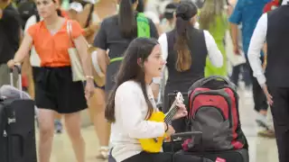 Turista ameniza la Terminal 2 del aeropuerto de Cancún al tocar su ukulele
