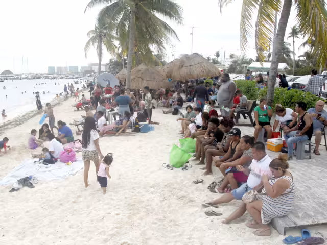 Bajo las palapas o palmeras, cientos de personas aprovecharon ayer, el día de asueto, disfrutaron del mar y el sol en Benito Juárez