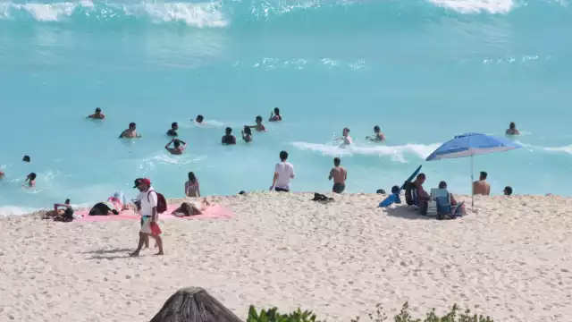 Desde temprano acudieron vacacionistas a la zona hotelera, donde colocaron banderas preventivas en los balnearios