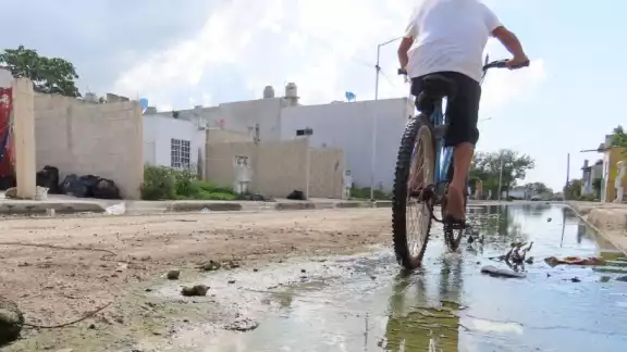 Niños transitan por las aguas residuales en bicicleta, en Kanasín Niños transitan por las aguas residuales en bicicleta, en Kanasín