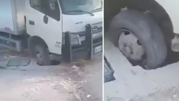 Un camión de caja cerrada se hundió en un registro de drenaje sin tapa en División del Norte, Escárcega