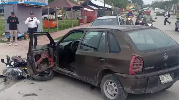 Chocan moto y Pointer frente al campo deportivo de Xpujil