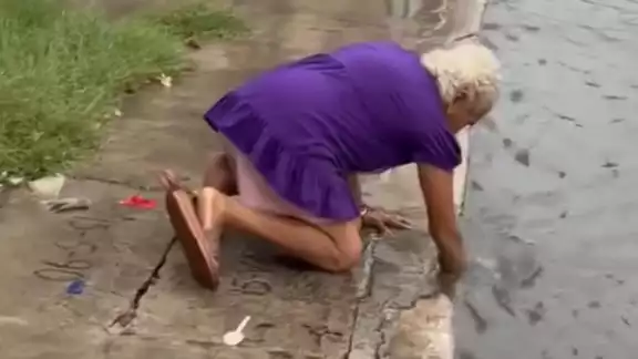 A pesar del riesgo de contraer una infección, la mujer tomó la determinación de limpiar la alcantarilla A pesar del riesgo de contraer una infección, la mujer tomó la determinación de limpiar la alcantarilla