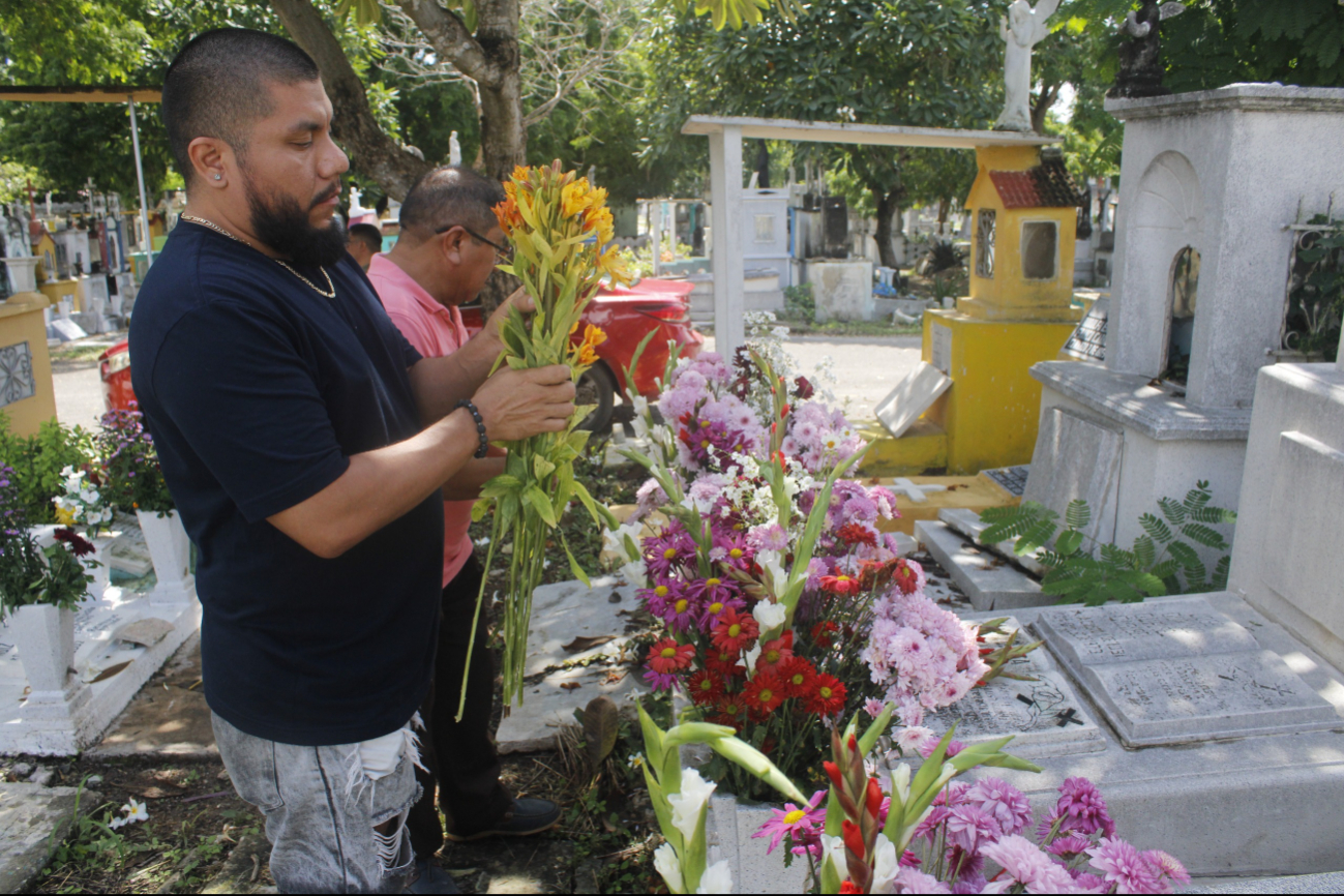 Familiares llevan flores a las tumbas de sus difuntos Familiares llevan flores a las tumbas de sus difuntos