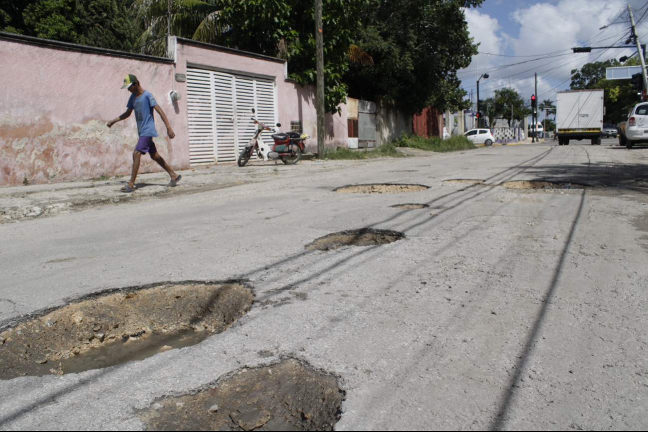 Los baches representan un peligro para vehículos y transeúntes Los baches representan un peligro para vehículos y transeúntes
