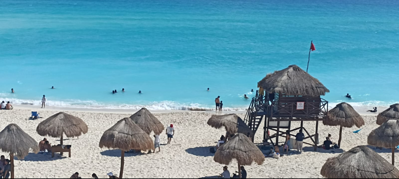 Algunas playas tienen la bandera roja, pero los turistas siguen nadando, con guardavidas exhortándolos a tener precaución Algunas playas tienen la bandera roja, pero los turistas siguen nadando, con guardavidas exhortándolos a tener precaución