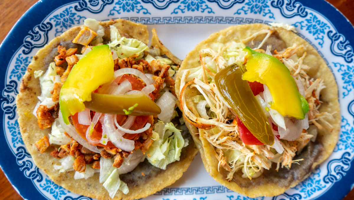 Tortillas de maíz fritas, rellenas de frijoles y cubiertas con carne, cebolla, lechuga y salsa Tortillas de maíz fritas, rellenas de frijoles y cubiertas con carne, cebolla, lechuga y salsa