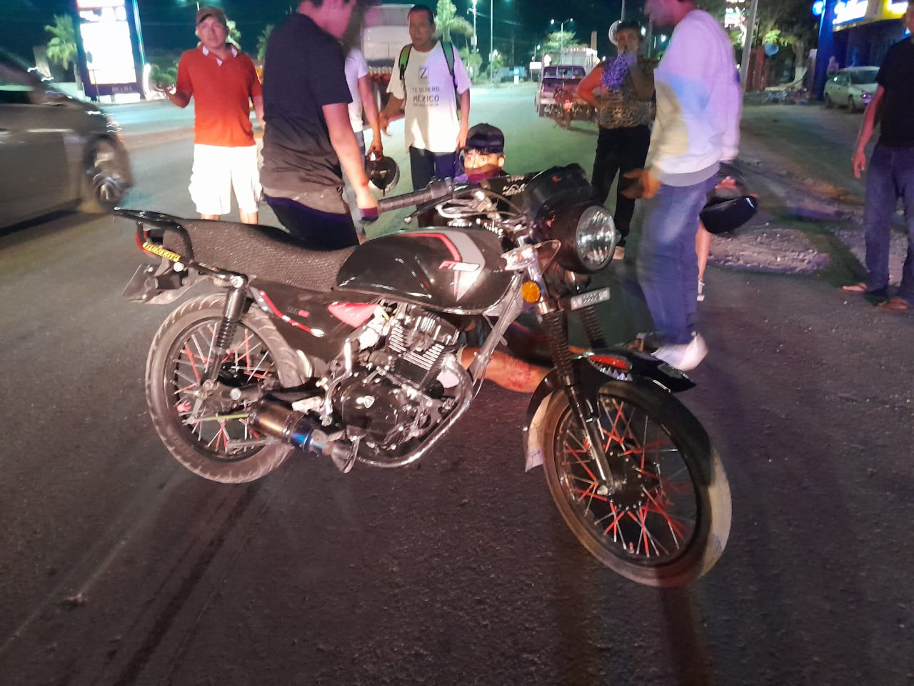 Personas resguardan la motocicleta involucrada en el accidente Personas resguardan la motocicleta involucrada en el accidente