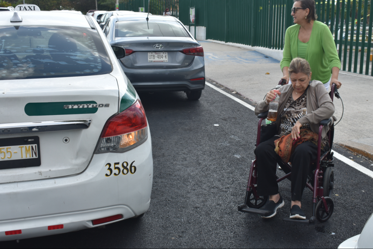 Las personas con discapacidad tiene que cruzar entre los automóviles sobre las avenidas en Cancún Las personas con discapacidad tiene que cruzar entre los automóviles sobre las avenidas en Cancún