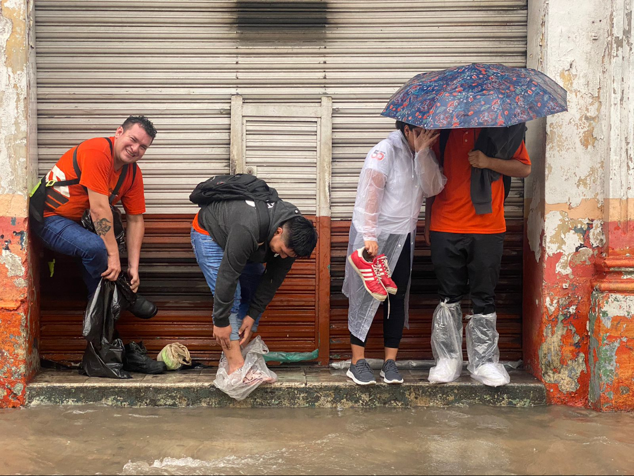 Trabajadores protegen su calzado, a causa de las inundaciones, en Mérida Trabajadores protegen su calzado, a causa de las inundaciones, en Mérida