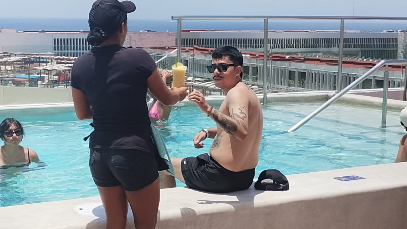 Huéspedes disfrutan de la azotea de un hotel en la Riviera Maya Huéspedes disfrutan de la azotea de un hotel en la Riviera Maya