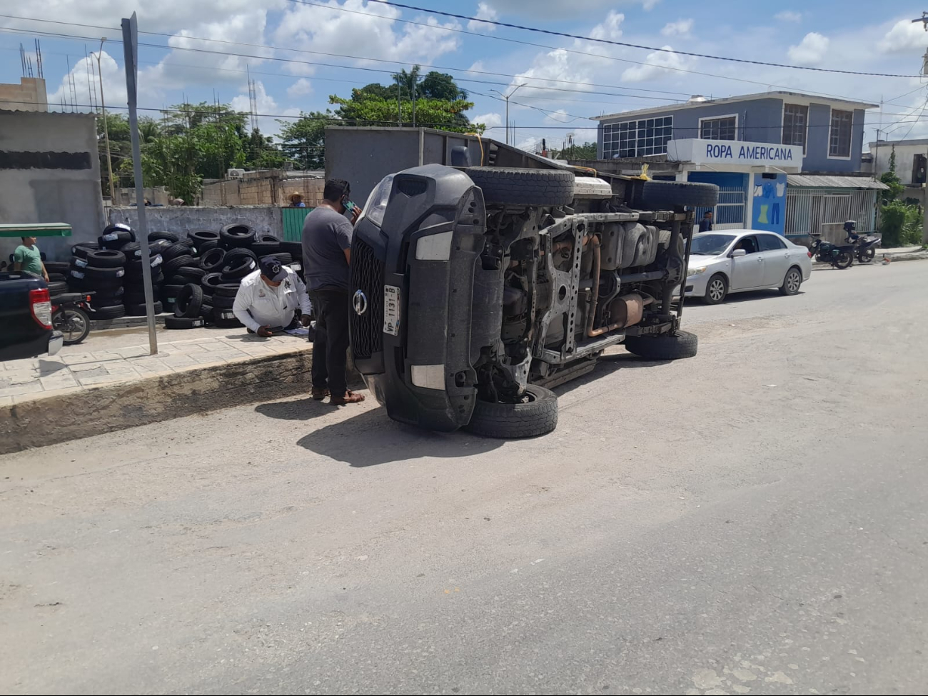 Una camioneta Nissan blanca se volcó debido al exceso de peso de su carga de llantas. Una camioneta Nissan blanca se volcó debido al exceso de peso de su carga de llantas.