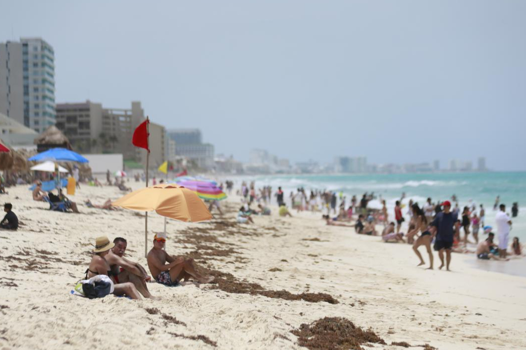 Turistas ignoran banderas rojas en playas de Cancún tras paso de Beryl