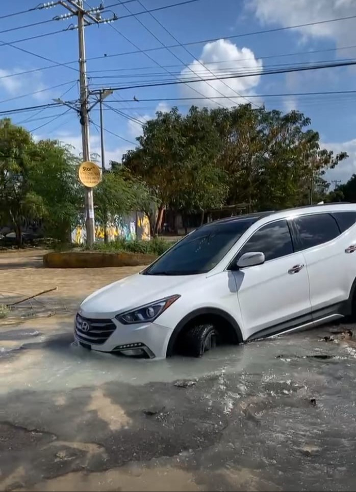 Revienta ducto de agua potable de Aguakan en Cancún y cae vehículo