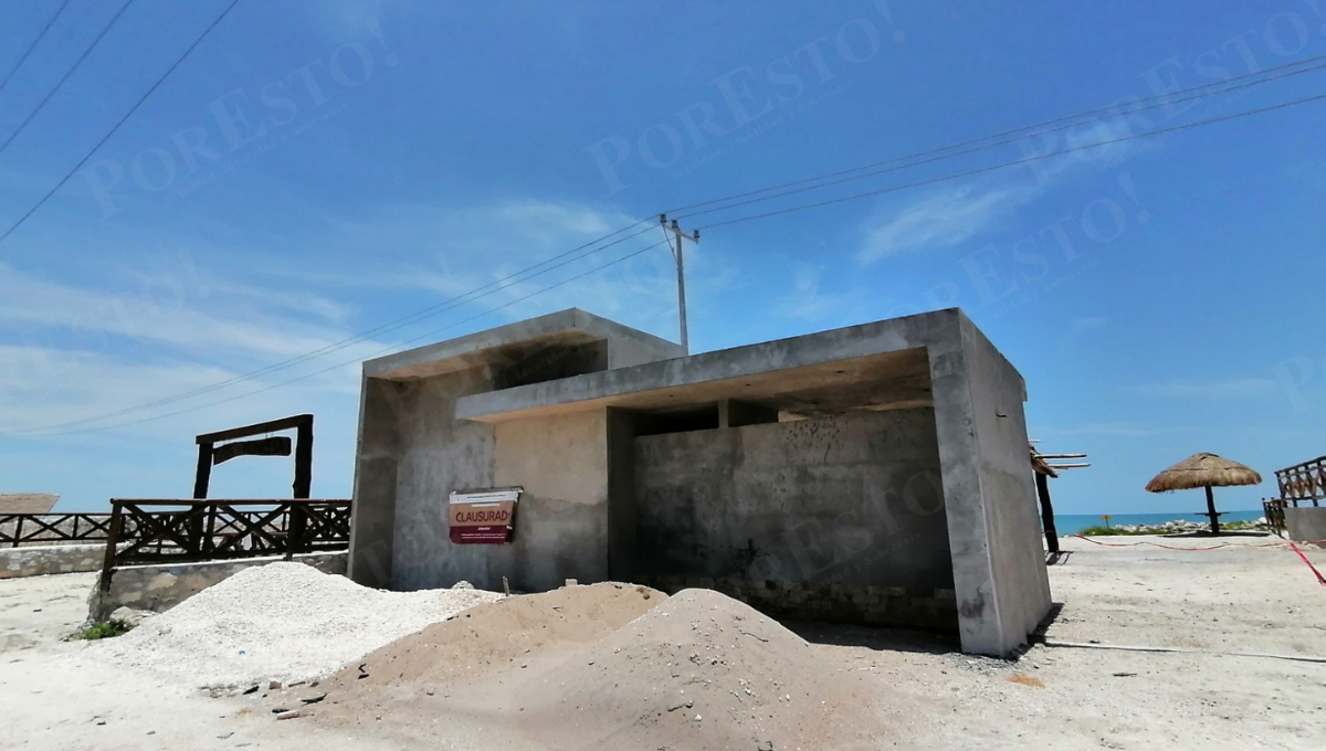 Se observa un paisaje de casas, palapas y estructuras abandonadas o en venta, construidas a escasos metros del acotamiento.