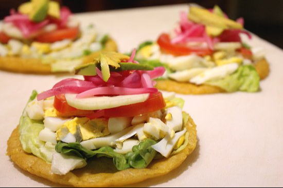 Los salbutes son tortillas fritas acompañadas de pollo y vegetales Los salbutes son tortillas fritas acompañadas de pollo y vegetales