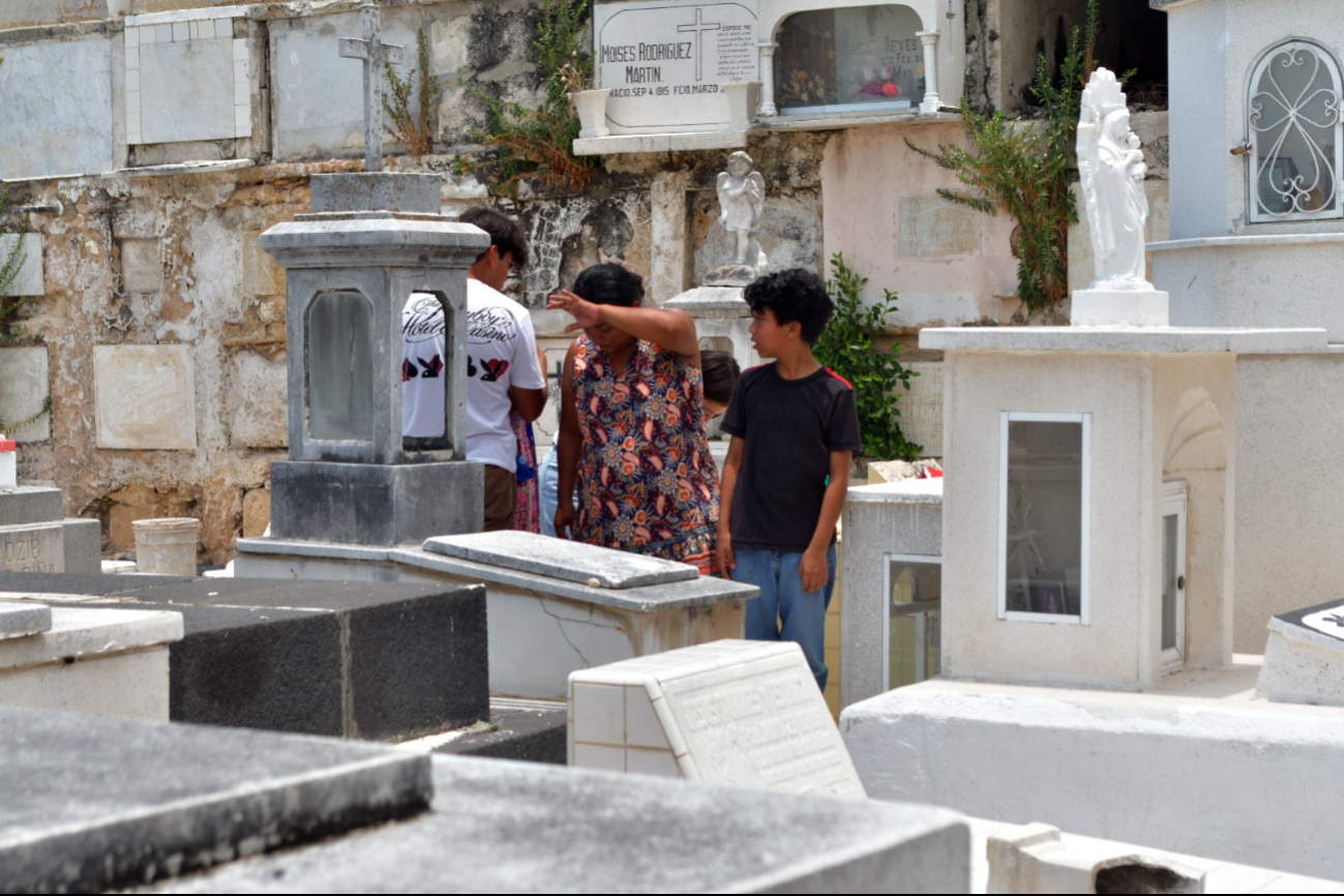 Los niños jugaban entre lápidas mientras los adultos lloraban y limpiaban mármoles recordando a sus mamás. Los niños jugaban entre lápidas mientras los adultos lloraban y limpiaban mármoles recordando a sus mamás.