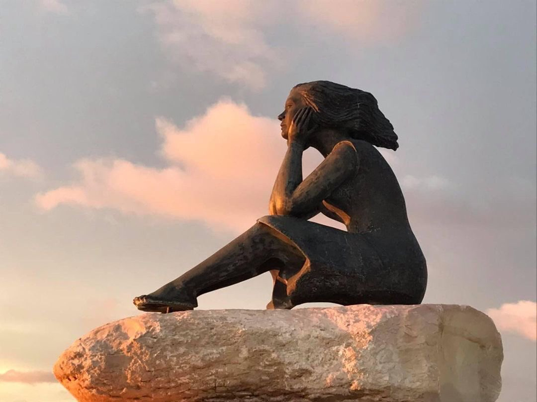 Representa a una mujer esperando a su amado perdido en el mar, evocando una leyenda de amor y nostalgia.
