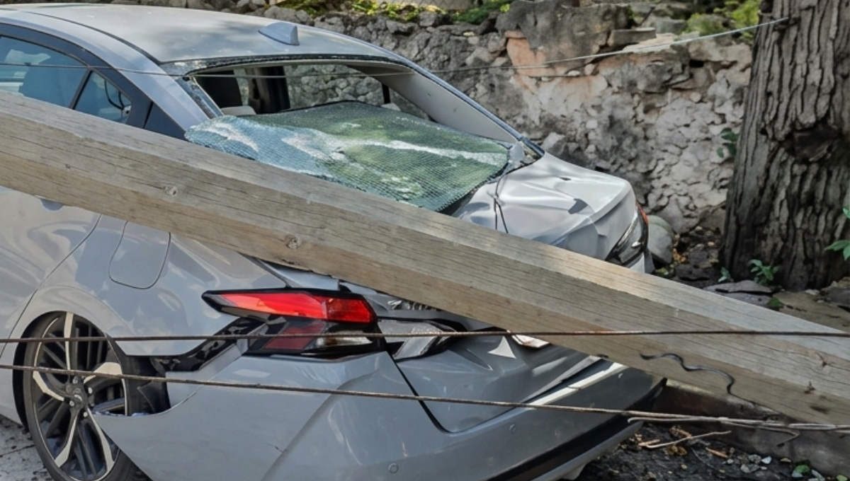 Cae poste de alumbrado sobre automóvil en Colonial Chuburná en Mérida