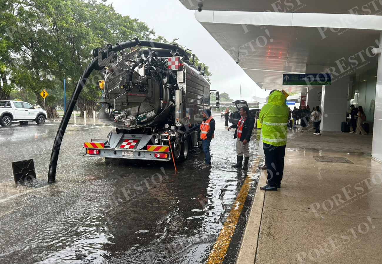 Trabajadores realizan labores para liberar coladeras y permitir que el agua acumulada por las lluvias pueda drenarse